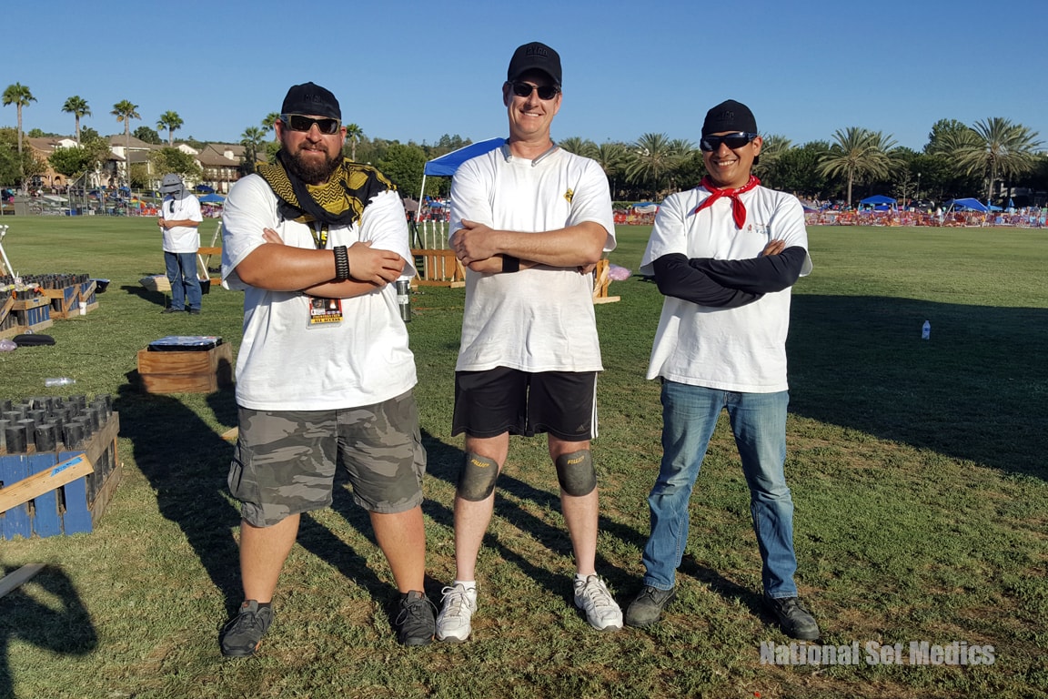 Three NSM crew members posing with arms crossed at an outdoor event