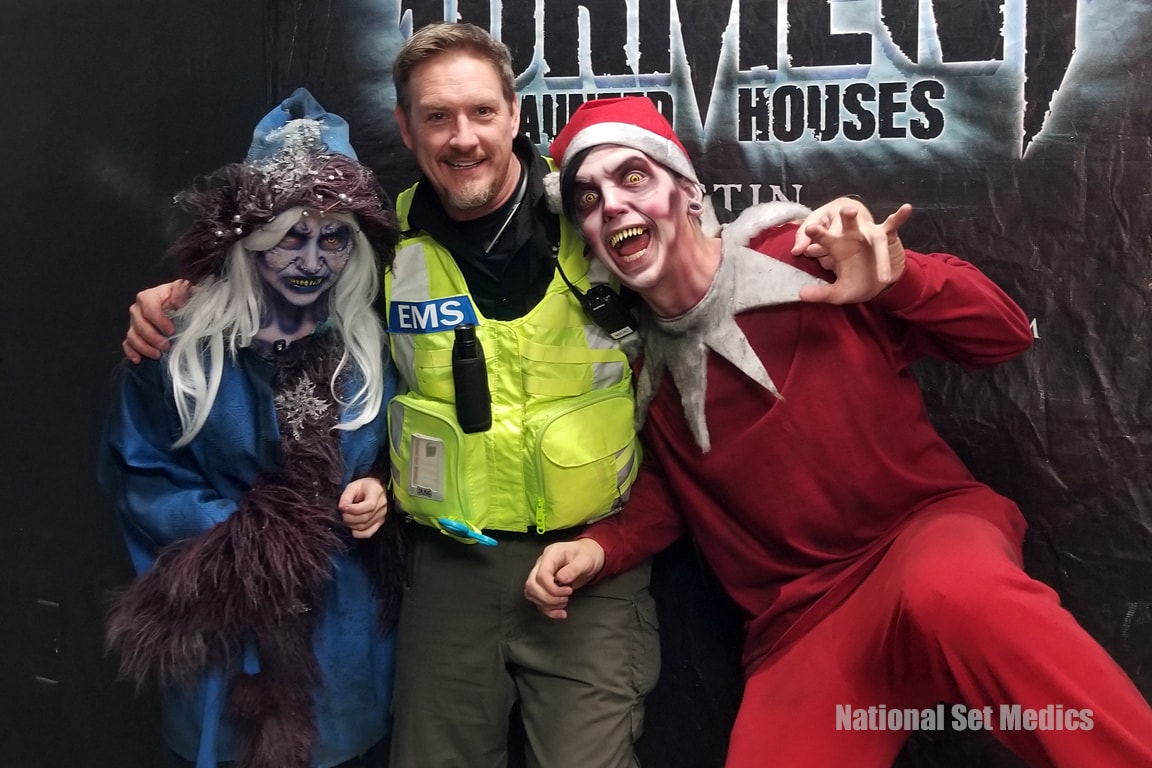NSM EMS medic posing with two costumed haunted house characters