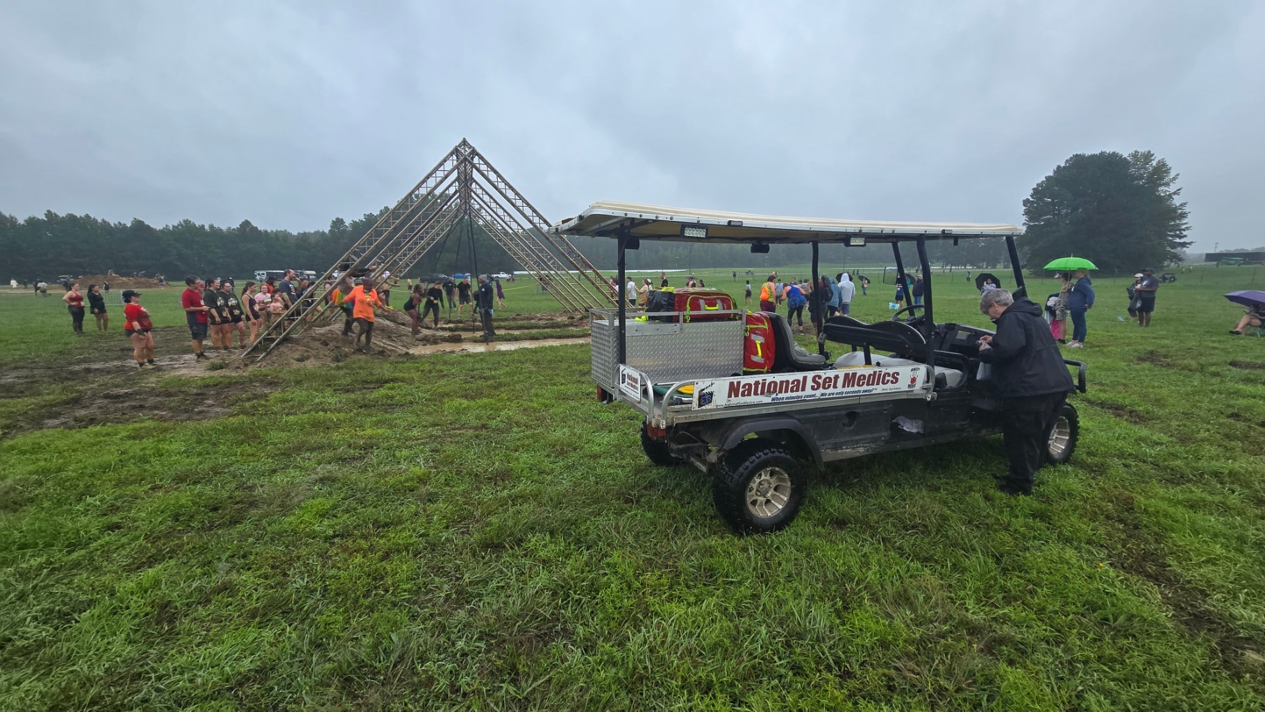 National Set Medics utility cart on a muddy field at an obstacle course event