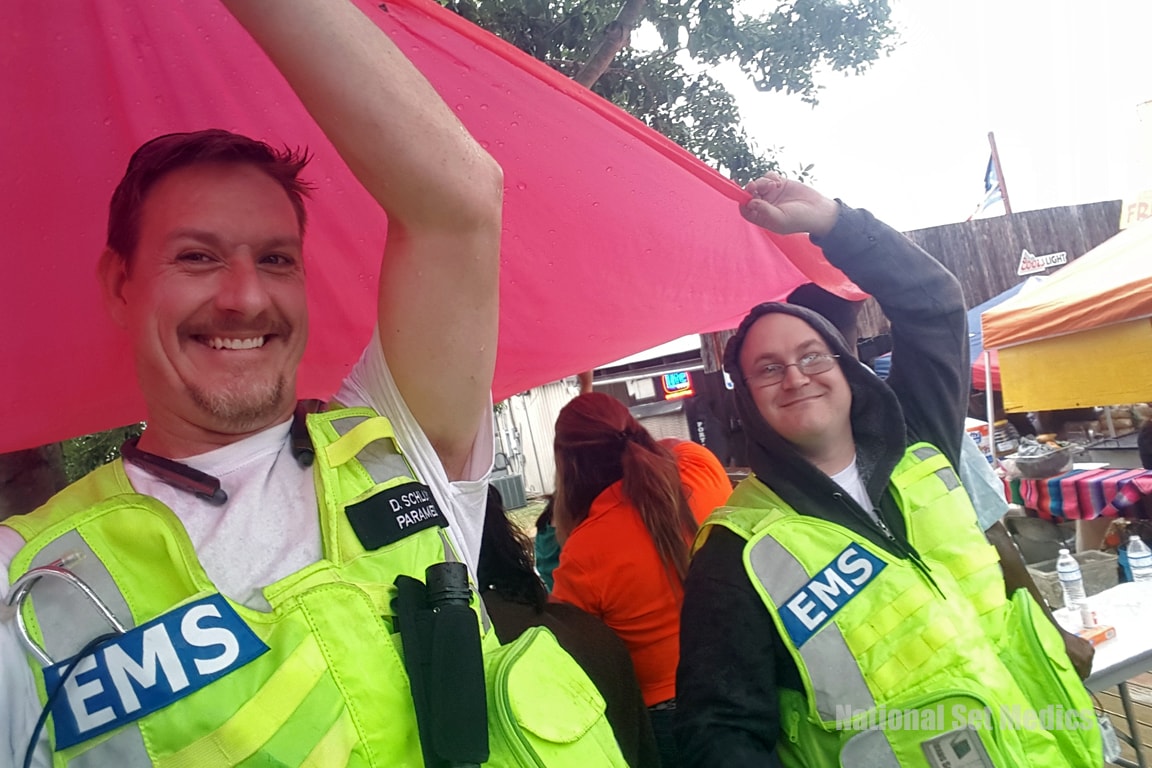 Two NSM EMS medics smiling in the rain at an outdoor event