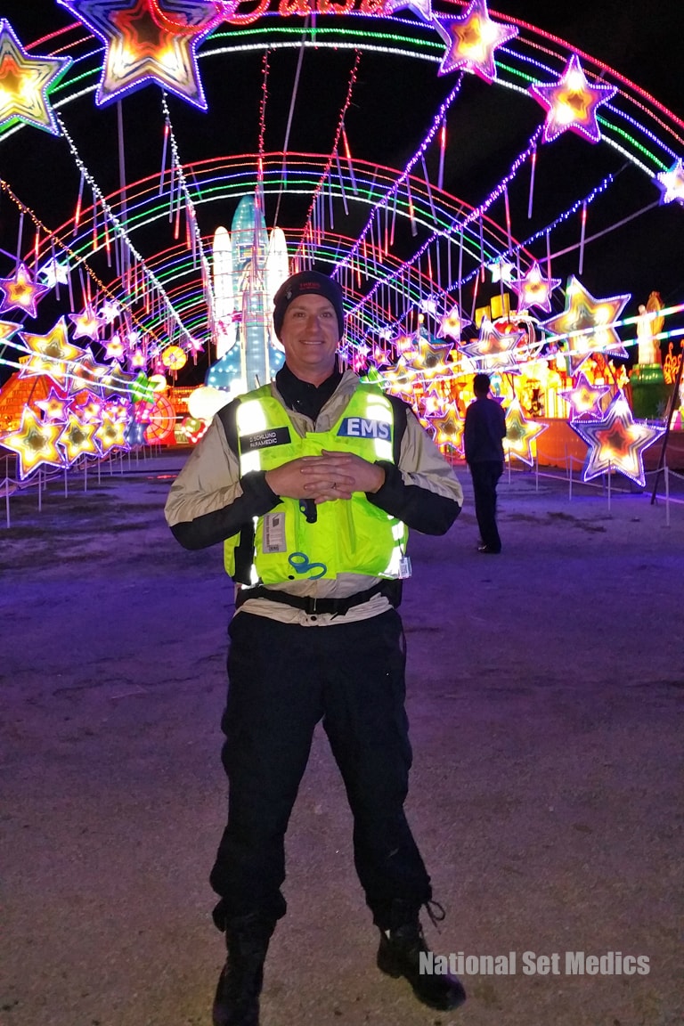 NSM EMS paramedic smiling inside the Magical Winter Lights display at night